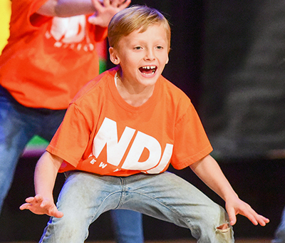 blonde kid on stage smiling