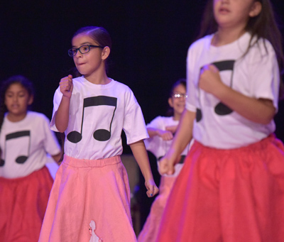 girls dancing on stage in poodle skirts