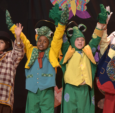 kids in costumes holding hands in air