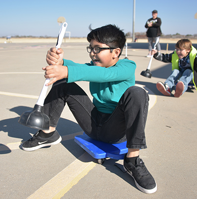 kid on skateboard with plunger