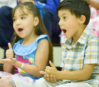 two kids singing and using sign lanugagee