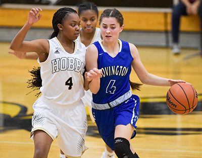 girl in white jersey guarding girl in blue jersey