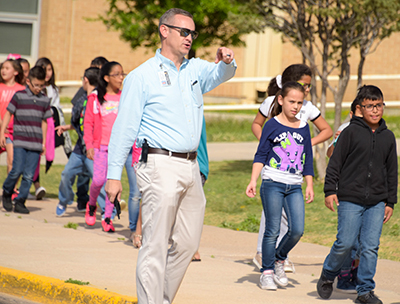 main pointing while children walk by