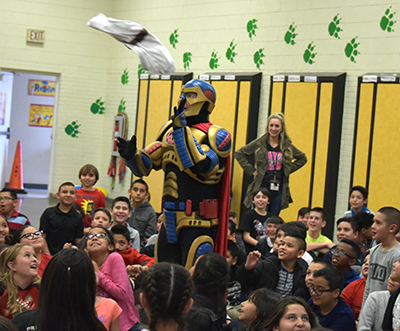 guy in superhero costume with students