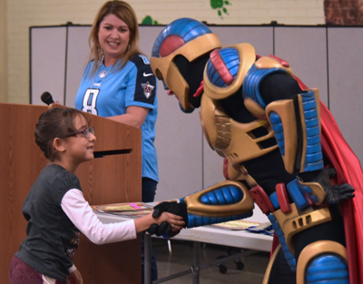 man in rockman suit shaking kid hand