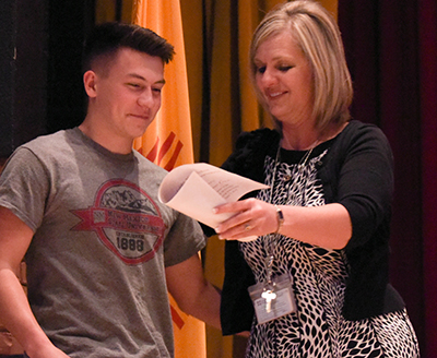 student with teacher getting certificate