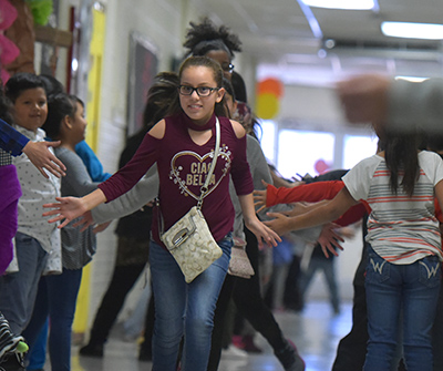 girl running down hall smiling