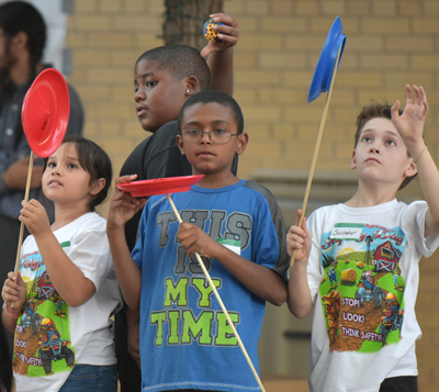 kids balancing plates on sticks