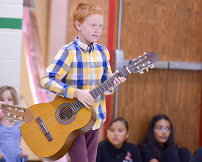 kid holding guitar