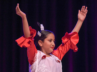 girl in costume with arms in air