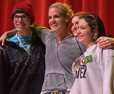 torres in middle posing with three students