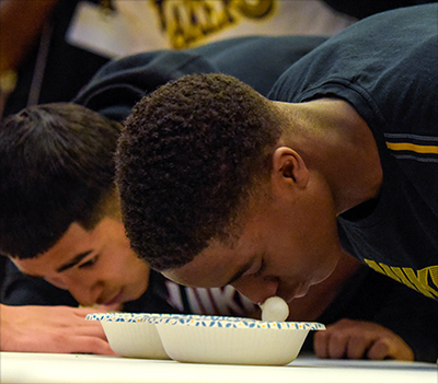 student with his nose in paper plate playing a game