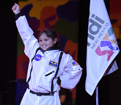 girl in astronaut suit with hand in air