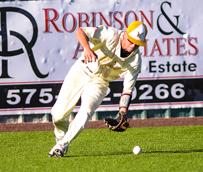 fielder bending over to pick up ball