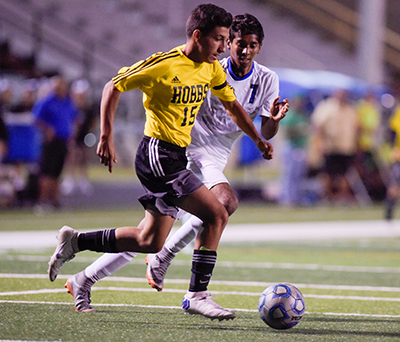 two players chasing a soccer ball