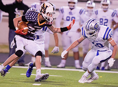 football player running with ball with arm up