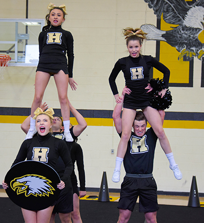 guys holding cheerleader girls in the air