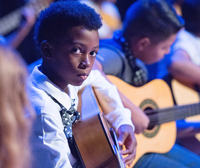 young student playing guitar