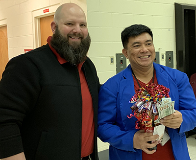 two smiling guys holding flowers