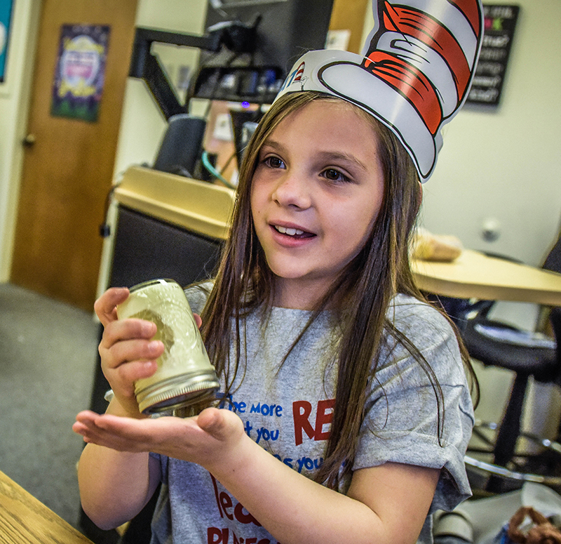 girl in dr seuss hat shaking butter