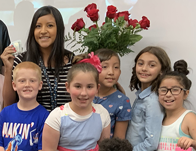 woman with flowers and students