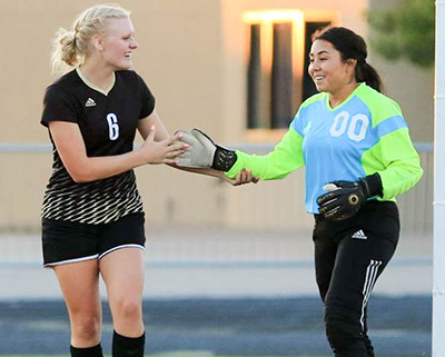 two smiling girls shaking hands