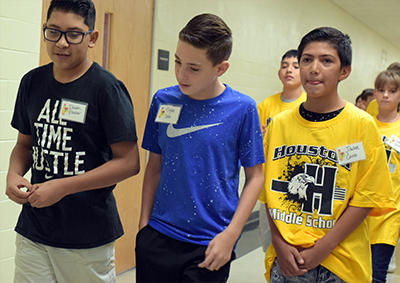 three students walking down hall