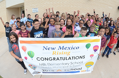 kids with banner in front of Mills