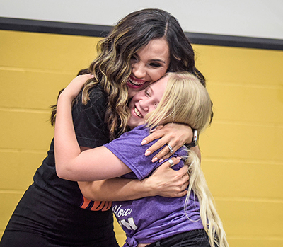 woman hugging fifth grade student