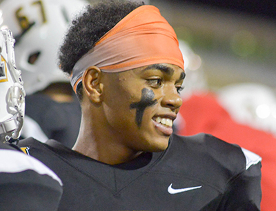 smiling football player without helmet looking sideways