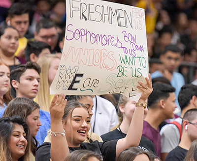 girl in crowd holding up sign