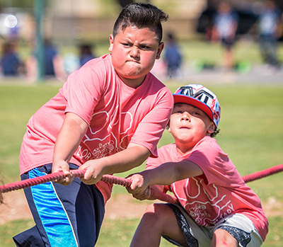 two kids frowning while doing tug of war