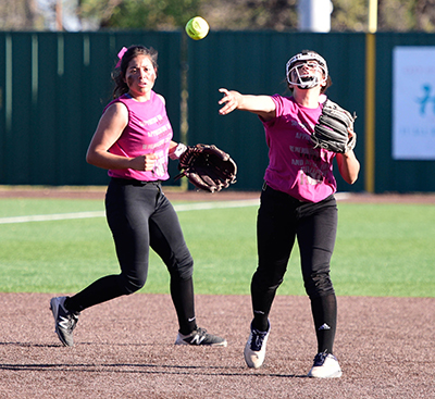 girl throwing ball to first base