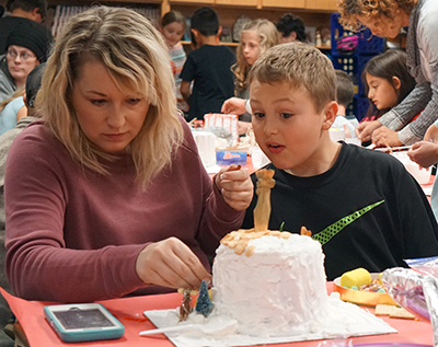 mom and son working on a candy house together