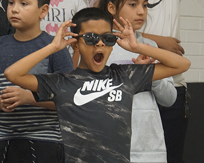 kid yawning while putting on sunglasses