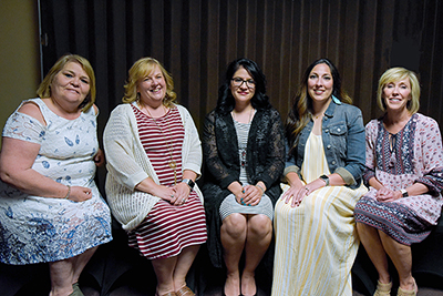 five women sitting in a row