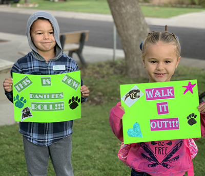 two students holding walk signs