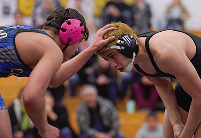 two wrestlings with heads together looking at each other