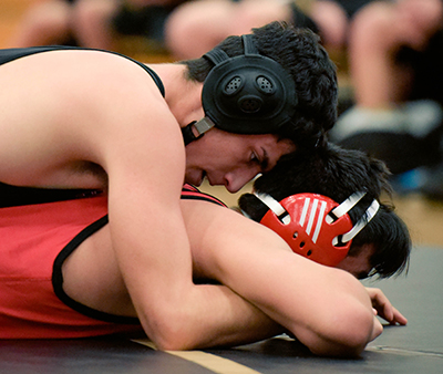 wrestler on top of another wrestler with close up of face profile