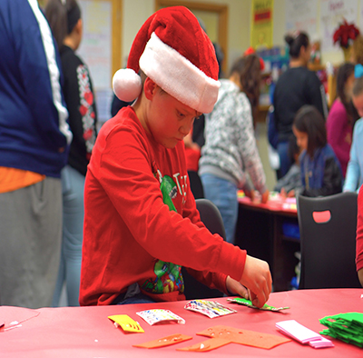 boy in christmas hat working on project