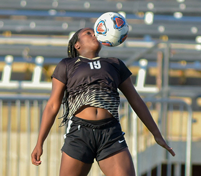 girl chesting soccer ball