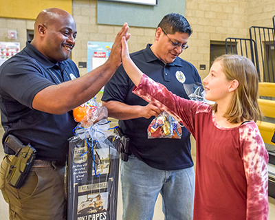 policeman high fiving student