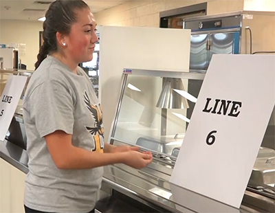 girl standing at cafeteria line