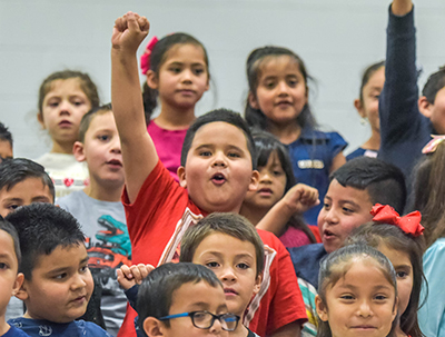 kid singing and raising fist