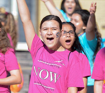 girl with arm raised smiling