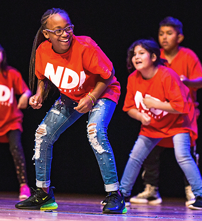 girl smiling while dancing on stage