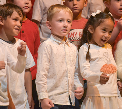 three little kids on stage smiling