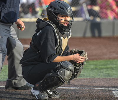 girl in catcher's crouch looking for signals