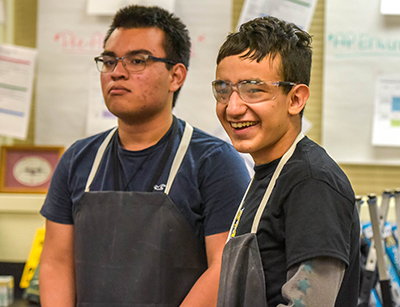 kid in lab apron and goggles smiling