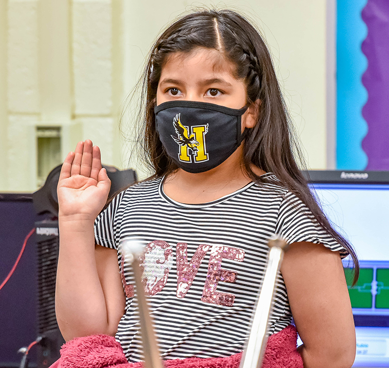 girl in mask with her arm raised